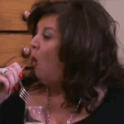 Woman With Red Nails Eating With Fork and Wine