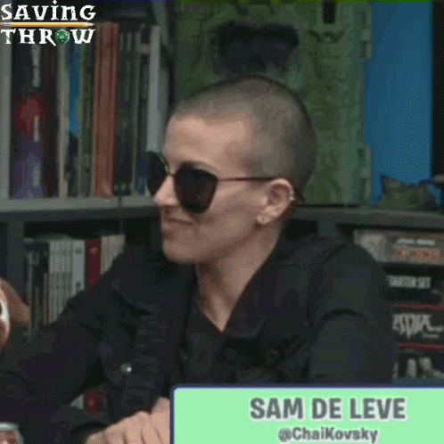 Woman With Shaved Head and Sunglasses Laughing in Front of Sam De Leve Sign