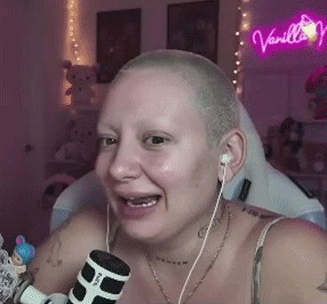 Woman With Shaved Head Wearing Earbuds Holding Microphone GIF