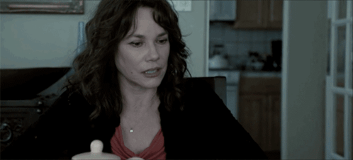 Woman With Small White Container At Table GIF