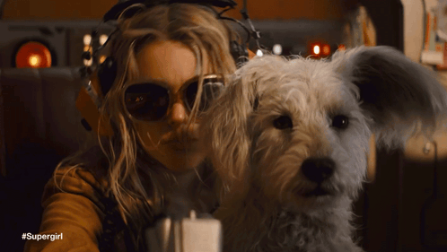 Woman With Sunglasses Headphones Holding White Dog #Supergirl GIF