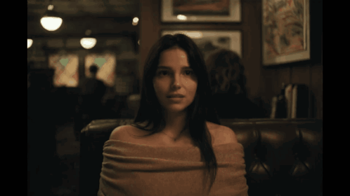 Woman With Sweater on Shoulders in Dark Room