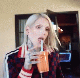 Woman With Tattoo Drinking From Cup GIF