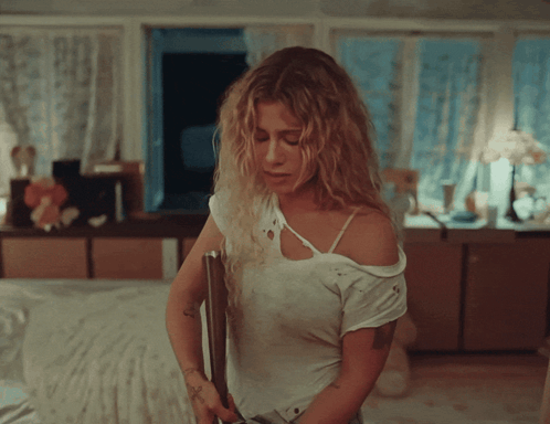 Woman with Tattoo Standing in Bedroom