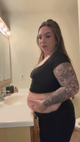 Woman With Tattoos at Bathroom Sink