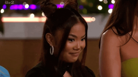 Woman With Two Buns Smiling Next to Another
