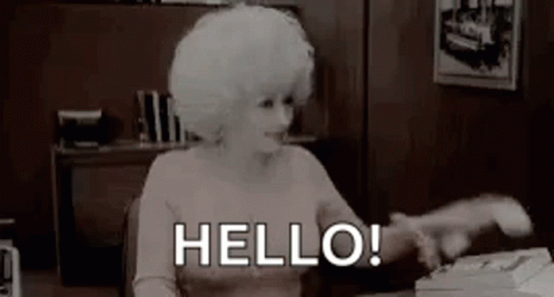 Woman With White Hair Sitting at Typewriter Saying Hello