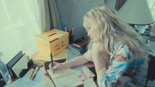 Woman Writing at Desk Next to Dot Box