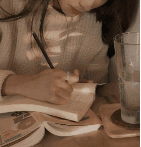 Woman Writing in Notebook at Table