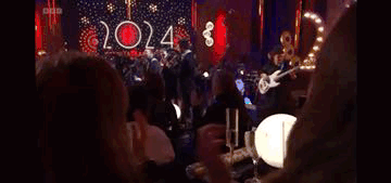 Women Clapping At Table In Dark Room GIF