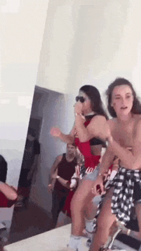 Women Dancing In A Room With Man In Background GIF