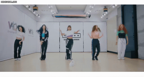 Women Dancing in Room With Amber Sign