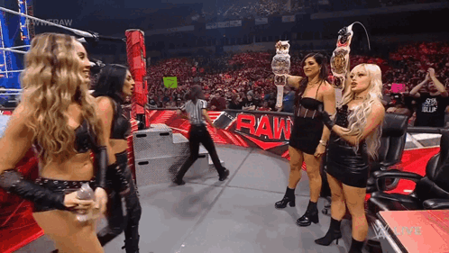 Women Holding Championship Belt on Stage