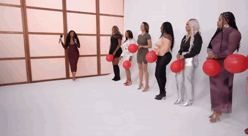 Women In A Row Holding Red Balloons GIF