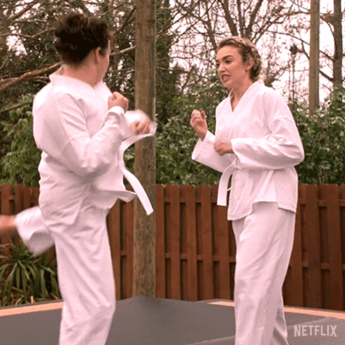Women in Karate Uniforms Kicking