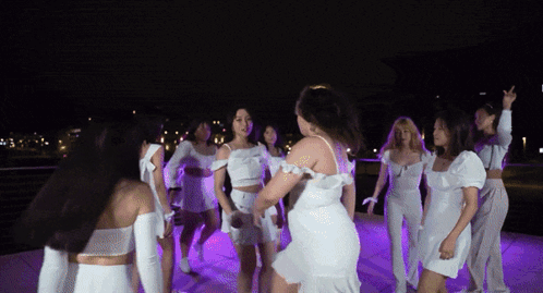 Women in White Dresses Dancing in Circle at Night