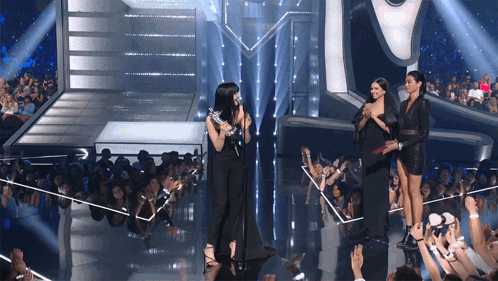 Women on Stage in Front of Crowd