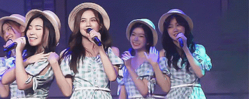Women Singing Into Microphones Wearing Straw Hats GIF