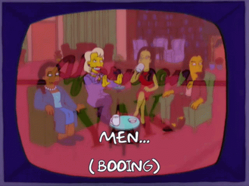 Women Sitting Around Table Booing Men