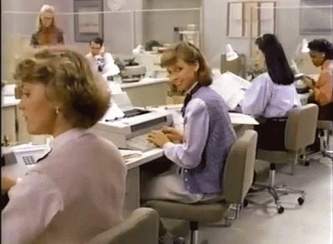 Women Sitting At Desks In Office With Printer GIF