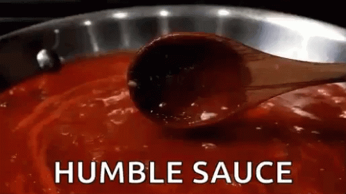 Wooden Spoon Dipped in Pot of Sauce