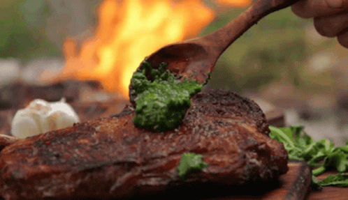 Wooden Spoon Spreading Pesto On Steak GIF