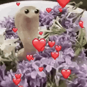 Worm Sitting On Plate Of Purple Flowers With Red Hearts GIF
