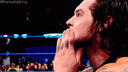 Wrestler Covering Mouth In Ring With Crowd GIF