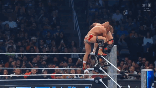 Wrestler Falling Through Ring While Referee Watches
