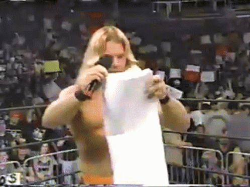 Wrestler Holding Paper in Front of Microphone