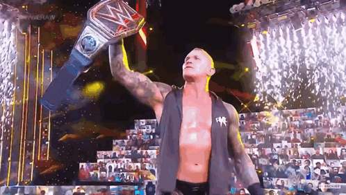 Wrestler Holding World Heavyweight Championship Belt Over Head