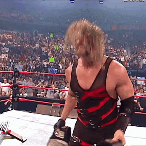 Wrestler in Black and Red Outfit in Ring With Crowd
