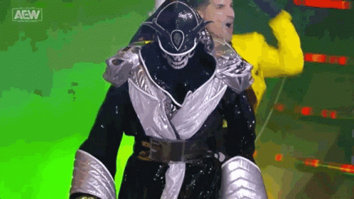Wrestler in Black and Silver Walking with Yellow Jacket Man