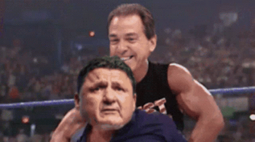 Wrestler In Black Tank Top Holding Opponent's Head GIF