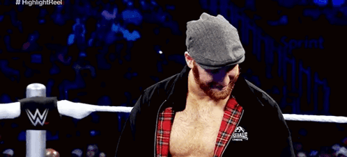 Wrestler in Hat and Plaid Shirt Covering Mouth