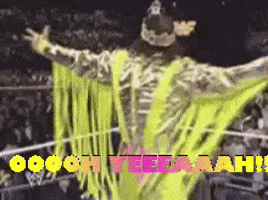 Wrestler In Neon Yellow Outfit Standing In Ring GIF