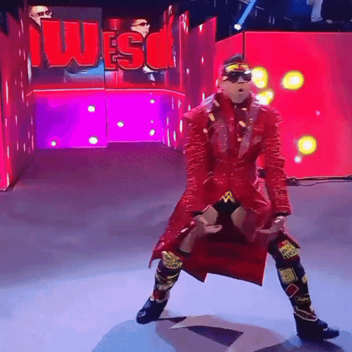 Wrestler in Red Coat Standing in Front of Wes Sign