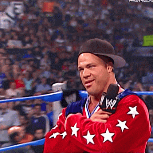 Wrestler In Red Jacket With Stars Talking Into Microphone GIF