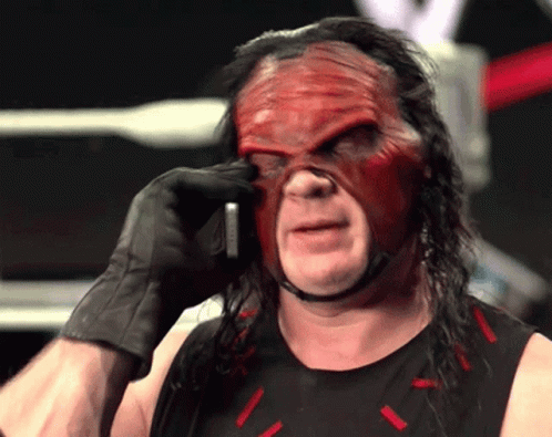 Wrestler in Red Mask and Black Gloves on Phone