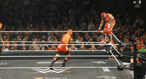 Wrestler In Red Outfit Jumping Over Ropes GIF