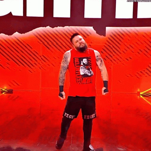 Wrestler in Red Tank Top and Black Shorts on Red Stage