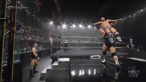 Wrestler Jumping In Ring While Another Stands GIF