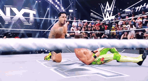 Wrestler Kneeling in Ring With Crowd Watching