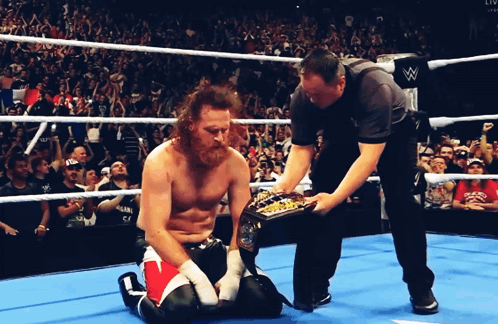 Wrestler Kneeling in Ring With Referee