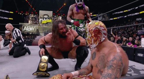 Wrestler Kneeling Next to Another in AEW Ring