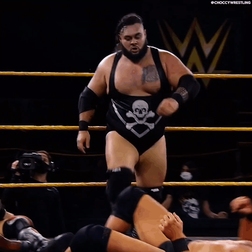 Wrestler Laying on Ground With Opponent Standing Over Him