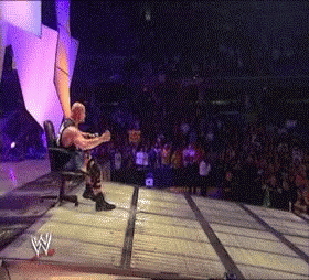 Wrestler Sitting In Chair On Stage With Crowd GIF