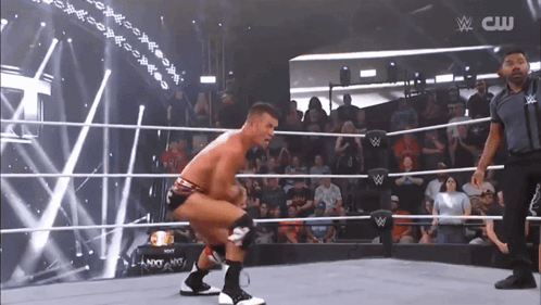 Wrestler Squatting In Ring With CW Logo GIF