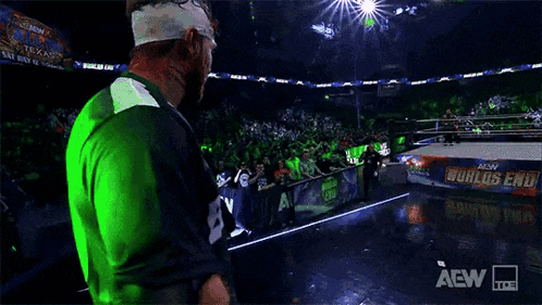 Wrestler Walking on Stage in Green and Blue Jersey