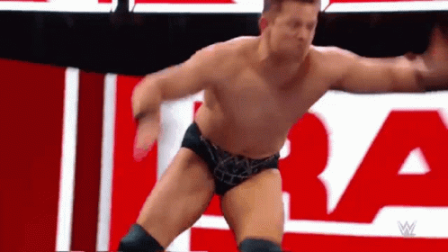 Wrestler Without Shirt In Front Of Red And White Sign GIF